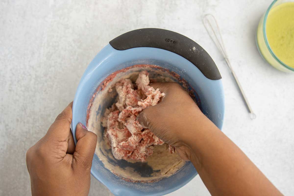 Kneading pink color into dough