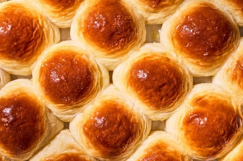 Overhead view of freshly baked dinner rolls on a tray. - select to zoom