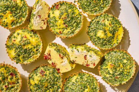 Egg Bites seen from the top showing greens and a cross-section of one with quiche like interior and cottage cheese within. - select to zoom