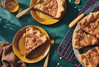Slices of Chocolate Chip Pecan Pie on plates next to the full pie