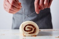Slicing cinnamons rolls with dental floss