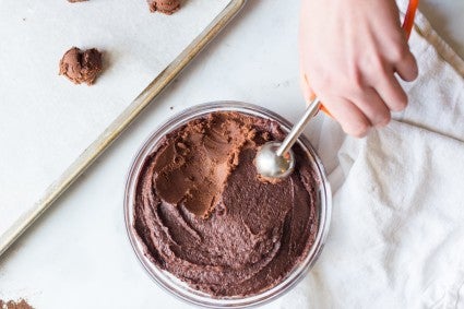 Scooping chocolate crinkle cookie dough