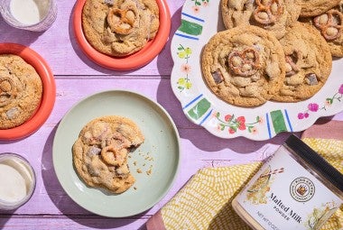 Malted Peanut Butter Chocolate Chip Cookies on plates arranged on a table, seen from above.